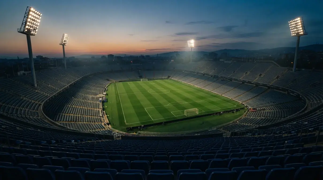 Een leeg voetbalstadion met lichtmasten bij schemering
