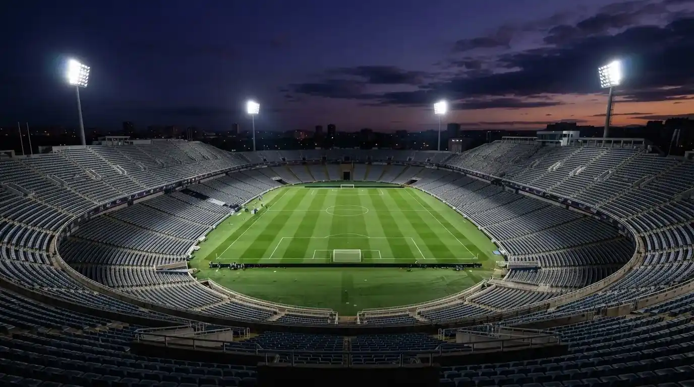 Een leeg voetbalstadion met lichtmasten bij schemering